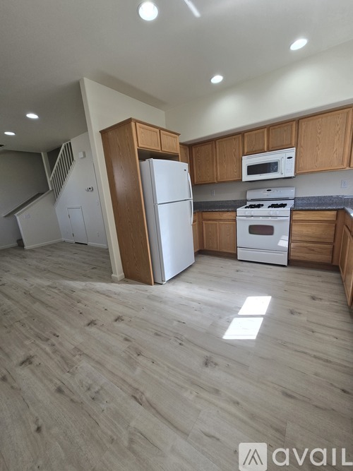 A kitchen with wooden cabinets and a white fridge.