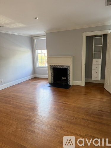 A room with a fireplace and wooden flooring.