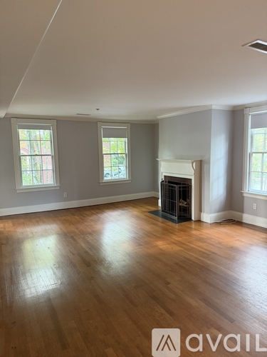 A room with a fireplace and wooden floors.