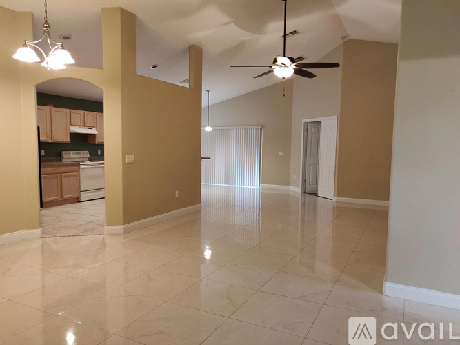 A spacious room with a marble floor and a ceiling fan.