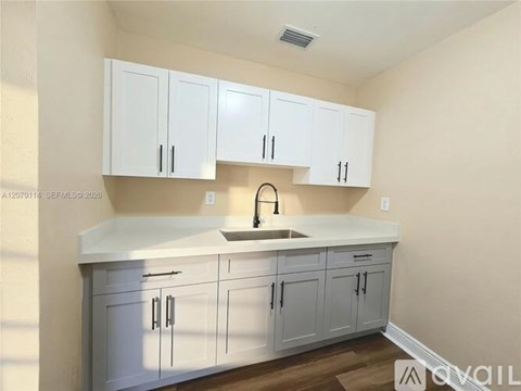 A kitchen with white cabinets and a white countertop.