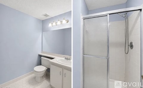 A bathroom with a toilet, sink, and shower.