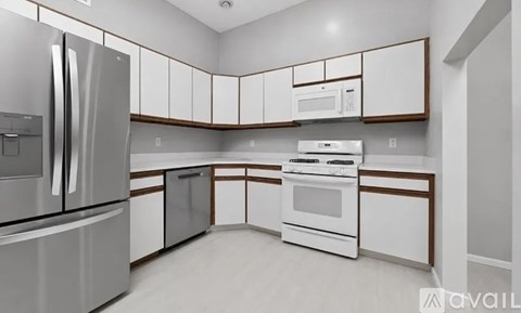 A modern kitchen with white appliances and cabinets.
