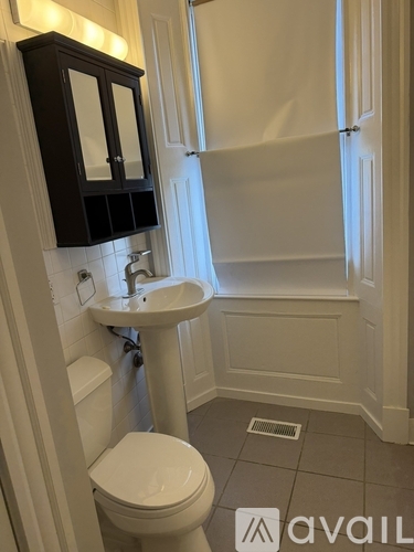 A bathroom with a toilet, sink, and mirror.