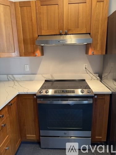 A kitchen with wooden cabinets and a stainless steel stove.