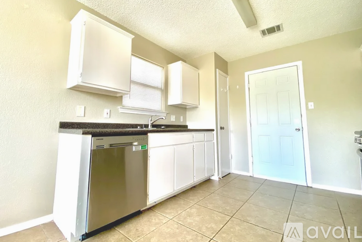 A kitchen with white cabinets and a stainless steel dishwasher.
