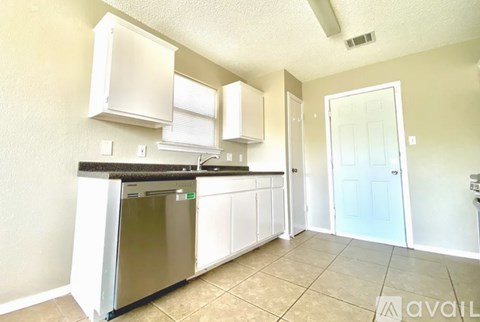 A kitchen with white cabinets and a stainless steel dishwasher.