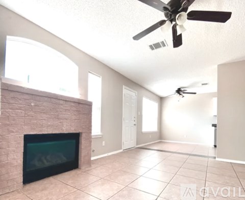 A living room with a fireplace and a ceiling fan.