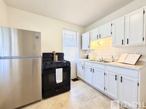A kitchen with a black stove and white cabinets.