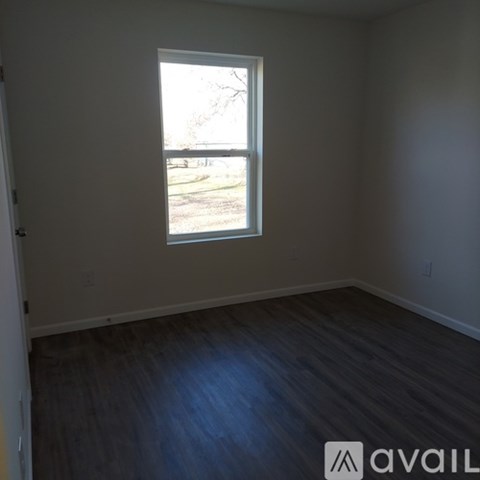 A room with a window and wooden flooring.