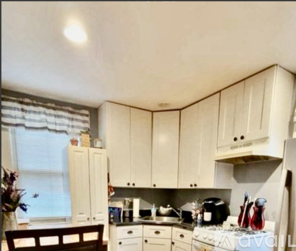 A kitchen with white cabinets and appliances.