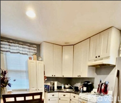 A kitchen with white cabinets and appliances.