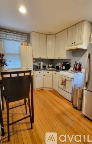 A kitchen with wooden floors and white appliances.