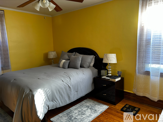 A bedroom with a bed, nightstand, and a ceiling fan.
