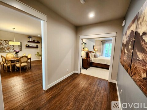 A bedroom with a large bed and a painting on the wall.
