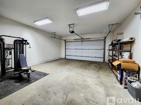 A garage with a gym setup and a black chair.