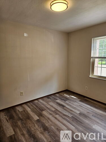 A room with wooden flooring and a window.