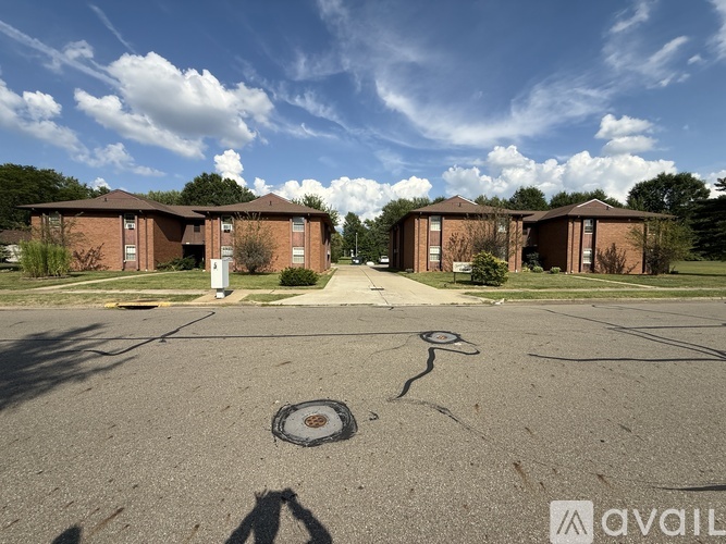 A sunny day at the empty parking lot in front of the brick apartment buildings.