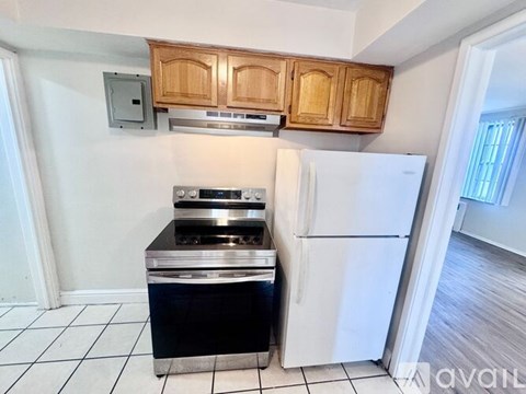 A kitchen with a white fridge and a black stove top oven.