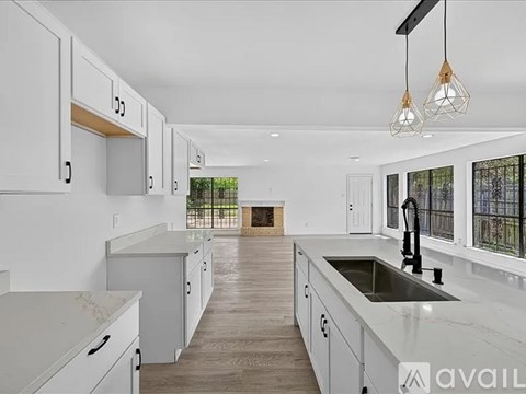 A kitchen with white cabinets and a marble countertop.