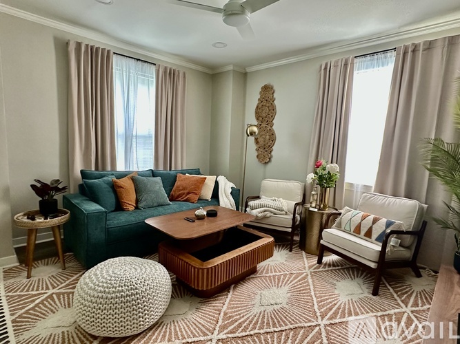 A living room with a green couch, a coffee table, and a white ottoman.