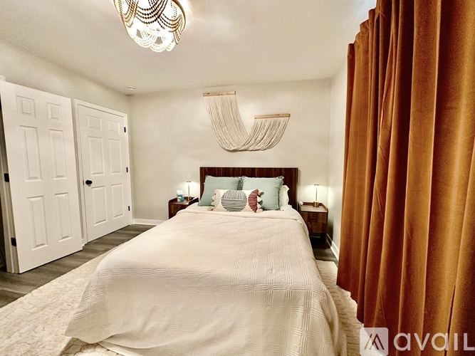 A bedroom with a large bed and a chandelier.