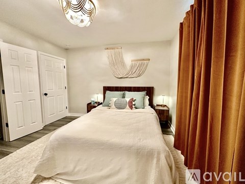 A bedroom with a large bed and a chandelier.