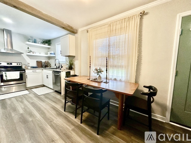 A kitchen with a dining table and chairs.