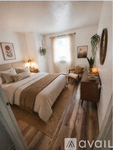 A bedroom with a large bed and a wooden floor.