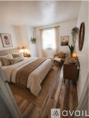 A bedroom with a large bed and a wooden floor.