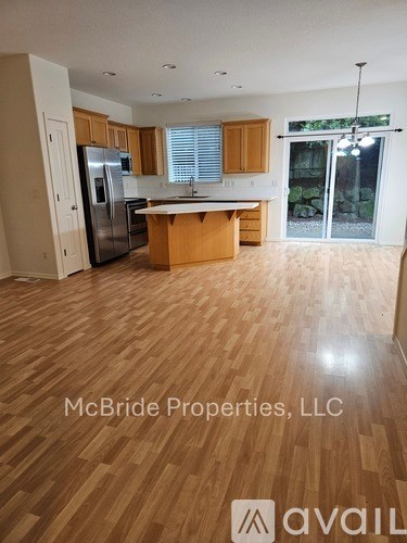 A kitchen with wooden floors and a refrigerator.