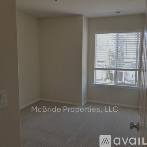 A room with a window showing a view of a building outside.