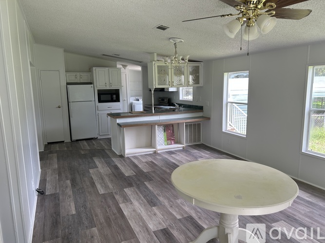 A kitchen with a table and a fan.