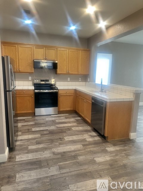 A kitchen with wooden cabinets and a tile floor.