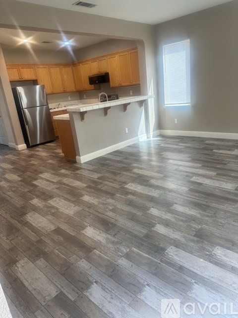 A kitchen with wooden cabinets and a stainless steel refrigerator.
