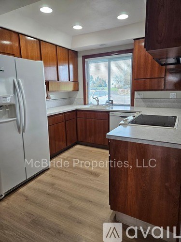 A kitchen with wooden cabinets and a white refrigerator.