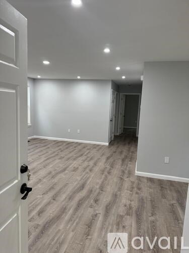 A room with a wooden floor and a white door.