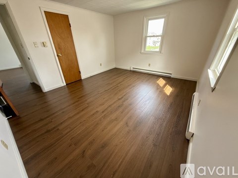 A room with wooden flooring and a window.