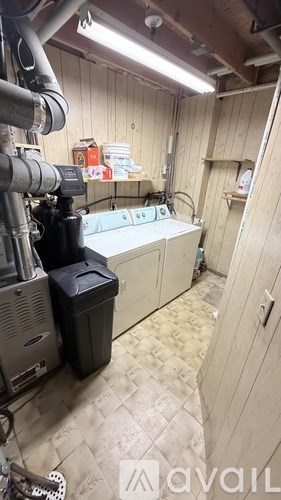 A room with wooden walls and a tiled floor contains a large machine and a cabinet.