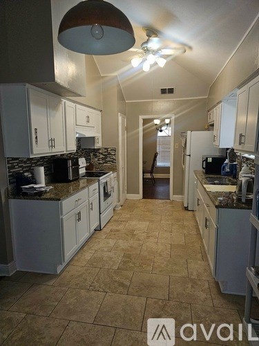 A kitchen with tile flooring and a tile backsplash.
