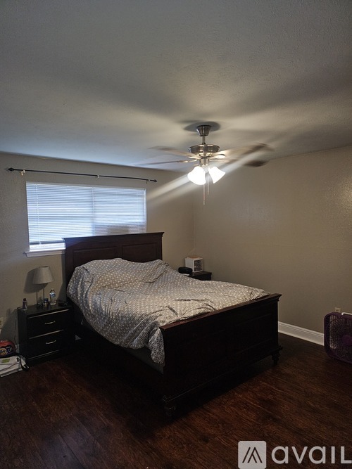 A bedroom with a bed, nightstand, and a ceiling fan.