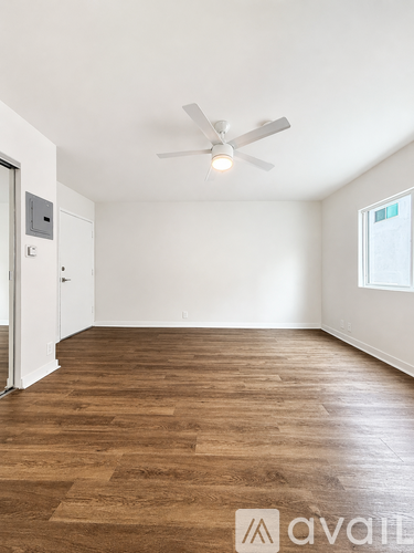 A room with wooden flooring and a ceiling fan.