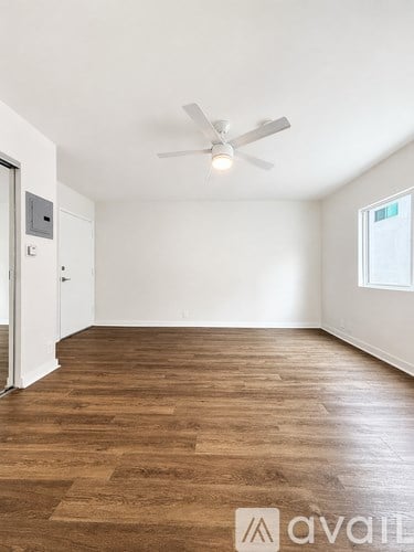 A room with wooden flooring and a ceiling fan.