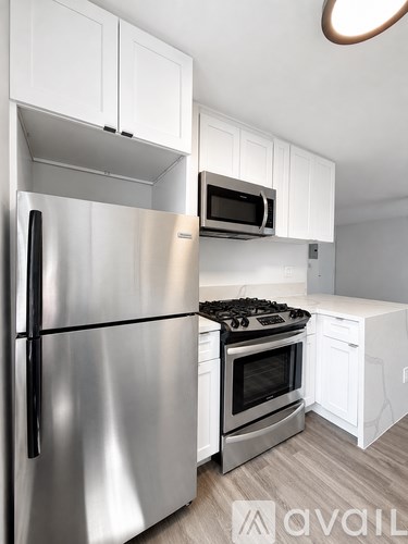 A modern kitchen with a stainless steel refrigerator and oven.