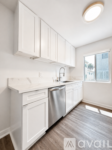 A kitchen with white cabinets and a stainless steel dishwasher.