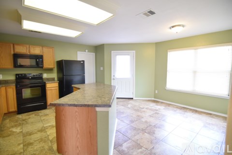 A kitchen with black appliances and wooden cabinets.