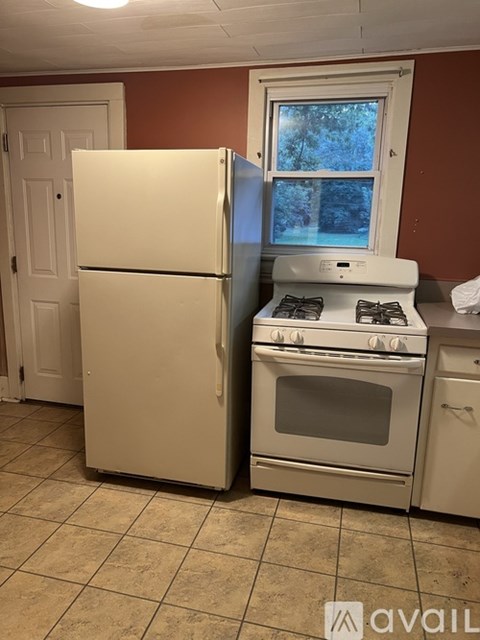 A white refrigerator and oven in a kitchen.