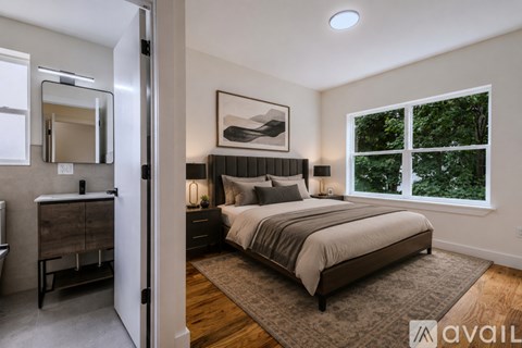 A bedroom with a large bed and a dresser with a mirror.