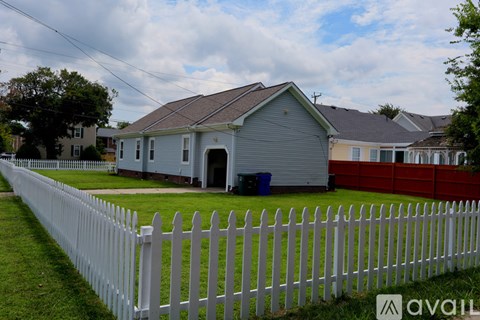 A white picket fence in front of a house.