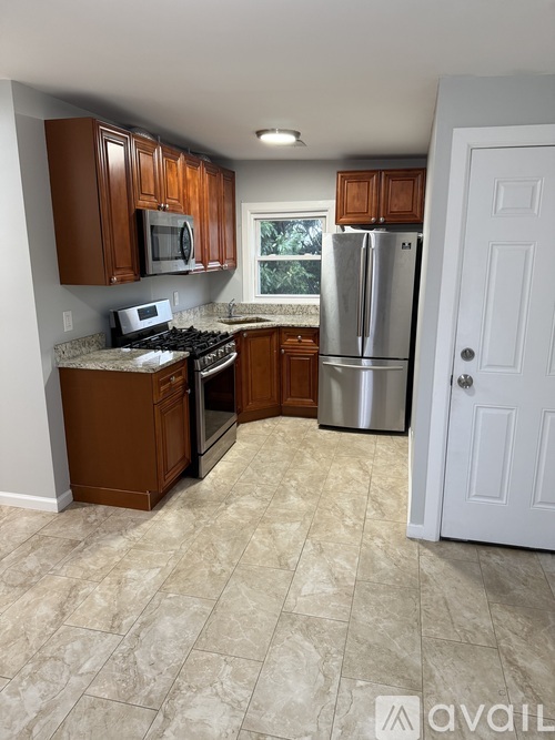 A kitchen with a refrigerator, microwave, and oven.